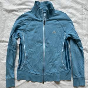 Unik Adidas blå zip up jacka i storlek 40, med tryck på både fram och baksidan 