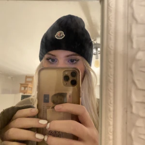 Moncler mössa  - Säljer nu min såå snygga marinblå moncler mössa som är köpt på NK för ungefär 2år sedan☺️Nypris 2299kr. Finns kvitto, tag och lappar med scanningkod i mössan😊Mössan är i nyskick, använts fåtal gånger. Billigare vid snabb affär, tveka inte på höra av dig Mvh Moa💞😚 