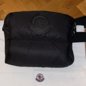 Moncler väska  - En Moncler väska som rymmer så som mobil plånbok nycklar m.m skick 9/10 jag har använt den ett fåtål gånger 