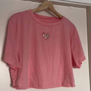 Plus size rosa cropped t-shirt med paljettdetalj. Knappt använd