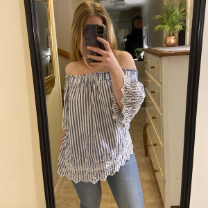 Blå-vitrandig sommartopp  - En lite mer bluslikande topp, dock med vanligt material. Fin med en kjol till eller några snygga byxor. Ärmarna har fina detaljer som nästan får personen som har på sig den att gå från söt till sommardröm. Tröjan ska gå under axklarna som på bilden. 