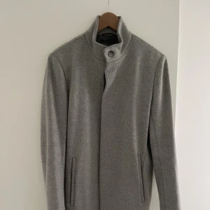 Theory kappa - En ljus grå kappa från theory i nyskick, ett fåtal gånger varsamt använt. Knapparna är på högersida, vilket gör kappan till en herrkappa, men kan användas av kvinnor också. Storlek S/M. Inköpspris lite över 8.000kr, säljer för 1400kr.