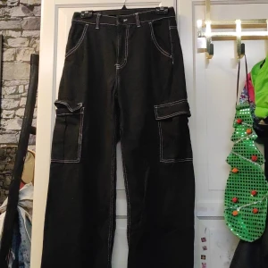 Svarta jeans - Sköna svarta jeans med vit synlig tråd. Väl använda, finns några fläckar från blekning nere vid fötterna, inget man tänker på.
