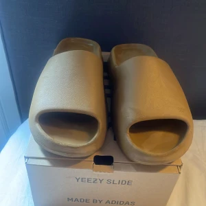 Yeezy slides - Säljer mina Yeezy slides då de nu är lite tajta på min fot. De är i storlek 44 1/2. De är i sick 8/10 Har både tags och original box kvar. Skriv vid minsta lilla fråga eller fundering 