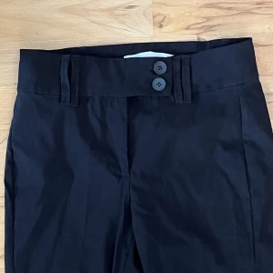 Svarta kostymbyxor - Fina kostymbyxor med knapp detaljer och två fickor på baksidan❤️ Aldrig använda. Säljer för att jag har liknande Strl 38 men passar mig som vanligtvis har 36☺️