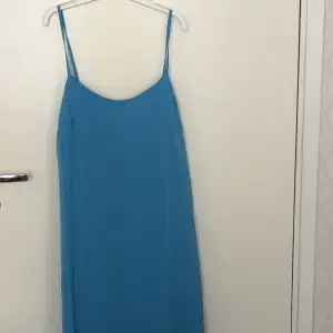 Blå flowy maxiklänning från NA-KD i storlek 34. Helt oanvänd och ny klänning med prislappen kvar.