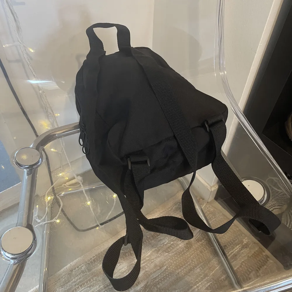 Liten svart ryggsäck från märket Dickies. Mini-ryggsäck 90tal stil. Supersnygg. Använd väldigt sparsamt, jättefint skick. Ser ut som ny. . Väskor.