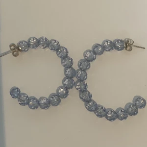 Blå plast pärlörhängen - Ett par blå pärlörhängen. Nästan oanvända. Inte äkta pärlor, de är i plast. 