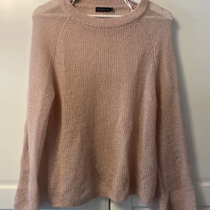 Rosa stickad tröja  - Rosa stickad tröja från Stockh lm. Något genomskinlig. Helt oanvänd. Vida ärmar. Storlek XS men passar nog även S. 