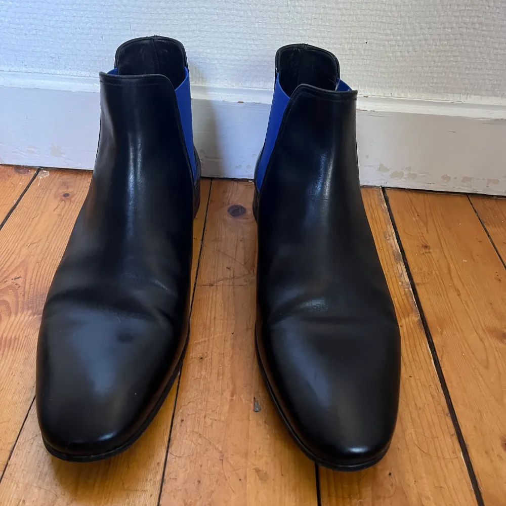 Knappt använda Pete Sorensen Phantom svart & blå skor i storlek 44. Väldigt bra skick. Handgjorda Chelsea boots tillverkad av ett enda läderstycke. Lätt och smidig italienskt kalvläder. Säljs nya av Pete Sorensen för 4450sek (380€). . Skor.
