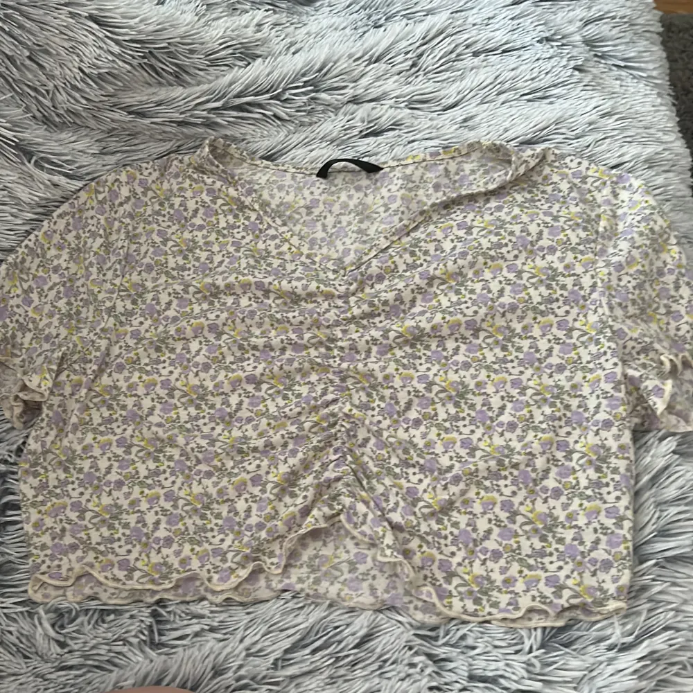 En vit tröja med lila och gula blommor på, bra skick storlek L, tror nypris va 50kr men är inte säker så säljer för 30💓. T-shirts.