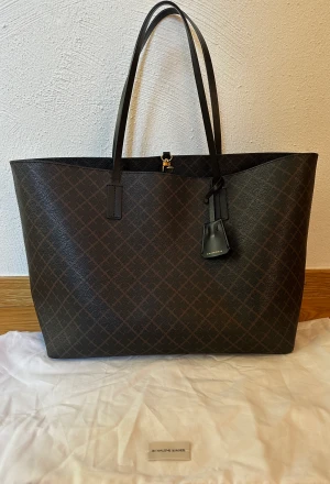 Malene Birger Abigal Dark Chocolate - Väskan är i fint skick bortsett från lite fläckar inuti och lite slitning på handtagen. Bredd 48 cm Höjd 28 cm Bredd 14 cm
