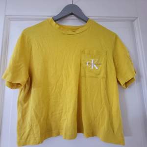 Jättefin gul Ck t-shirt, i mycket gott skick, så fin nu till sommaren! Lite croppad, så kort i storleken 