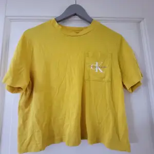 Jättefin gul Ck t-shirt, i mycket gott skick, så fin nu till sommaren! Lite croppad, så kort i storleken 