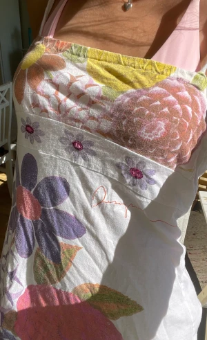 Blommig klänning - En supersöt blommig klänning med små paljetter. Den är avklippt