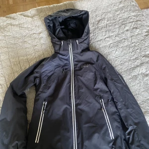 Helly Hansen skidjacka  - Super snygg skidjacka med massor av fickor, går även att ta bort luvan om man vill det.