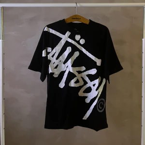Stussy tröja - En svart stussy tröja med stort tryck på framsidan. Storlek Large.