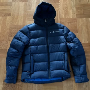 Sail racing vinterjacka  - Blå sail racing dunjacka i mycket bra skick använd förra vintern ett få antal gånger och har växt ur den nu nypris 3000 kr pris kan diskuteras vid snabb affär 