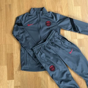 PSG Tracksuit - Grå och skön psg sett. Köpt i den officiella psg butiken i Paris. Byxorna och toppen är storlek L i barnstorlek. Skriv för fler frågor.😊