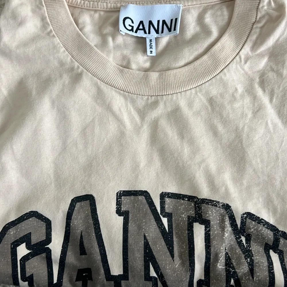 Super fin Ganni T shirt i färgen beige. Använd fåtal gånger. Super fin tröja till skolan. Tröjan är i storlek M och sitter super fint på alla. . T-paidat.