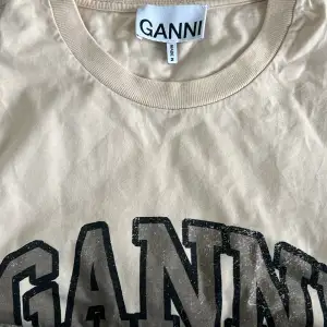 Super fin Ganni T shirt i färgen beige. Använd fåtal gånger. Super fin tröja till skolan. Tröjan är i storlek M och sitter super fint på alla. 