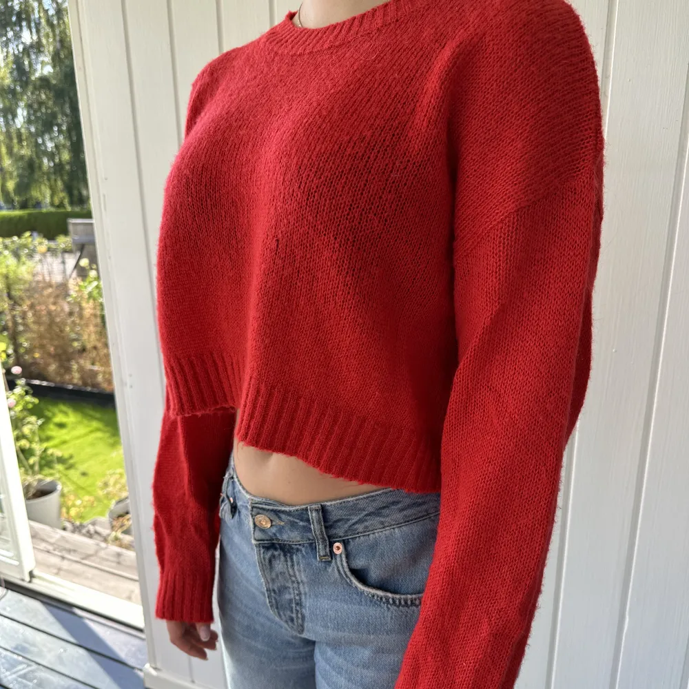 En söt röd liten croppad sweater. Stickad men ger en väldigt tunn känsla ändå.   . Stickat.