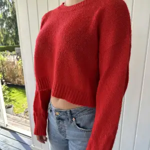 En söt röd liten croppad sweater. Stickad men ger en väldigt tunn känsla ändå.   