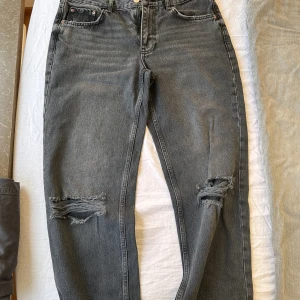 Svarta jeans midrise med hål på knäna.  - Svarta midrise jeans med hål på knäna. Supersnygga men de är alldeles för stora för mig nu. Använda endast en gång därav inga bättre bilder 