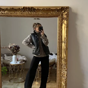 Svart vadderad Pu väst - Säljer min gamla favorit väst från NA-KD i storlek 34. Den är i superfint skick och inga tecken på användning! Jätteskön, supersnygg och varm (perfekt nu till hösten). Säljer då jag tyvärr inte använder den längre! Nypris är 699kr, slutsåld på hemsidan.