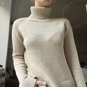 Peak performance stickad tröja - Finstickad turtleneck från peak. Beige och vit melerad. 