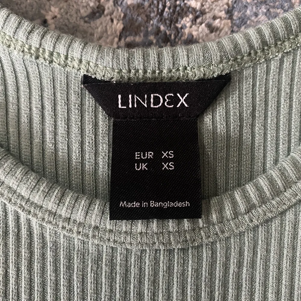 Ett enkelt men snyggt linne från Lindex Fin grön färg i ribbat material  Storlek XS. Toppar.
