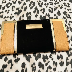 Dam plånbok från River island - Mycket fin dam plånbok från River island.  Gott om utrymme och fack finns.   Ny då den ej använts alls.  Färg, svart (mocka), beige, guld.   ”Pris går att pruta” 