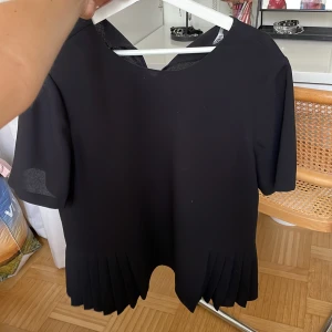 Svart topp  - Svart topp med volang strl L från zara. Mycket fint skick, inga defekter! Hör av vid frågor, fraktar mot köparens bekostnad samt möts upp Stockholm💗