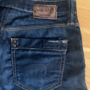 Ett par jeans med fina detaljer på fickorna 