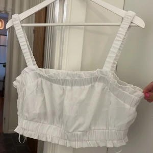 Croppad top H&M - Supergullig topp från H&M i storlek L med resår över och under bysten. Fint skick förutom en liten fläck på sidan nära armhålan. Syns inte jättemycket när man har den på sig.