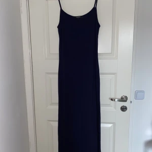 Långklänning  - En marinblå långklänning som endast är använd 2 gånger. Den sitter mot kroppen men är lösare ner till benen. Har en likadan i grå som jag också säljer (Se annons i min profil)