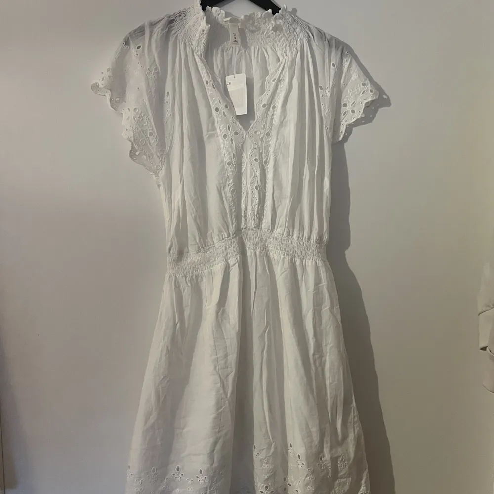 ( Fler bilder kan tas, hel vit i ”vanligt ljus” )  Helt ny klänning från H&M nypris 299kr Jätte fina detaljer dubbel kjol så ej genomskinlig, klänningen är i storlek 40 . Klänningar.