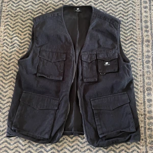 Tunn Cargoväst - Storlek: L (M), från Sweet Sktbs. Knappt använd och är i bra skick. Har nice texture och många fickor, helt tryckfri 