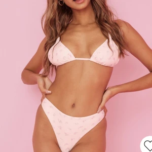 Bianca x Nelly bikini - Bikini top i storlek S och underdel i XS från Bianca Ingrossos kollektion med Nelly. Vit med rosa små blommor. Använd 2 gånger men är tyvärr för liten 😩. Nypris för hela setet blev 498 kr men säljer för 250 kr. Skriv för fler bilder!