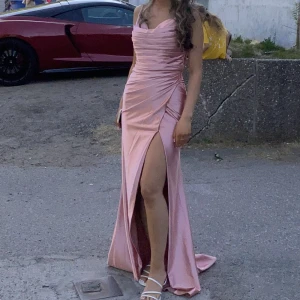 Festklänning  - Rosa skimrig festklänning i storlek 34. Använd endast en gång och är som ny. Pris 1000kr men kan diskuteras. 