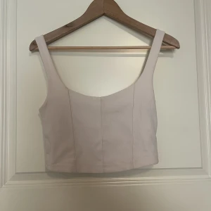 Crop top - Beige topp, ser ut att vara mer rosa aktigt på bilden mer är egentligen beige. Korsett aktigt topp som är använd en gång. Lappen är borta men jag tror den är från bershka och är i storlek m. 