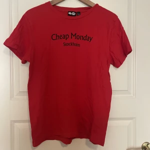 Cheap monday T-shirt  - En röd cheap monday T-shirt som är använd ett fåtal gånger. Inga synliga defekter. 