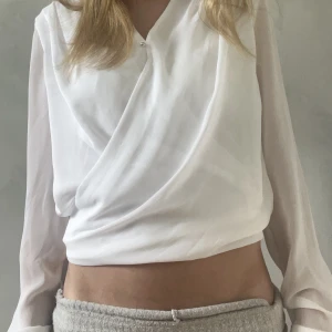 Vit tunn blus - Vit blus från Hm. Tunn och superskönt material med omlott tyg på mitten. Funkar till både lite festligare tillfällen men också vardagliga.