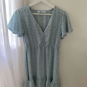 Ljusblå klänning med vita blommor - Den perfekta sommarklänningen. Storlek 36. Använd 1 gång. Som ny!