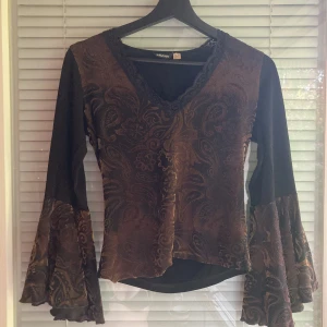 Långärmad tröja - Långärmad tröja med mjukt tyg på framsidan. Volang armar och spets runt halsen. Str. M 