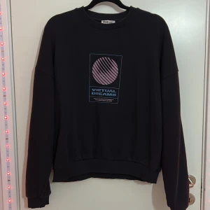 Svart sweatshirt med tryck - Jag säljer en svart sweatshirt med ett coolt snyggt tryck på ryggen, väl använd med tecken på användning, är villig att diskutera pris💝💘🧸