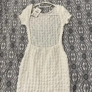 Vit klänning med öppen rygg - Endast testad (lapp finns kvar). Köpte för kanske 4 månader sen men aldrig kommit till använding.  Storleken är S men passar XS då den är rätt så tight men stretchig med:)