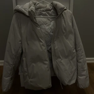 Uniqlo jacka - En beige/grå varm och fluffig jacka från uniqlo i storlek XS men passar även S. Den är i mycket bra skick. Skriv för fler bilder.