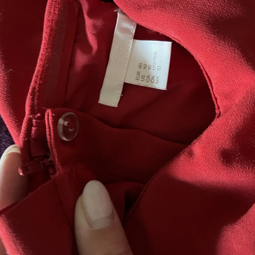 En röd byxdress från H&M. Använd 2 gånger. Stängs i ryggen med dragkedja och knapp. Är strl 40/L men jag skulle säga att den sitter mer som en 38/M. Frakt tillkommer. Kostymer.