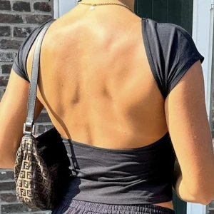 Svart topp med öppen rygg - Första bilden är lånad! Helt ny och bara testad!! Säljer då jag inte är bekväm i den men annars är den skön och sitter bra! Skriv vid frågor och mer info❣️